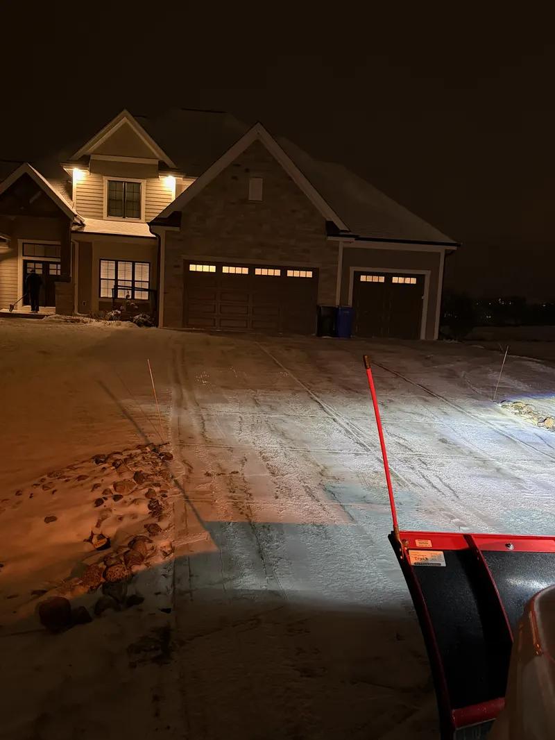 Snow removal plow truck operating at night in Madison, WI